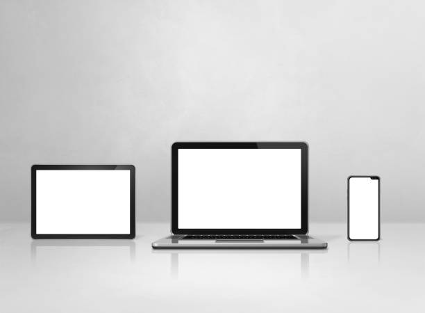 istock Laptop, mobile phone and digital tablet pc on white concrete office desk 1291142818