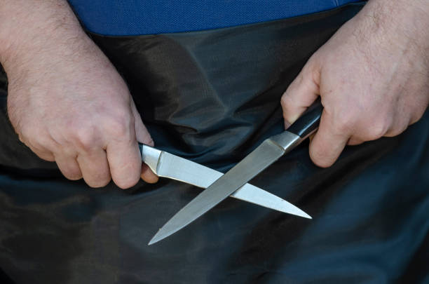 istock Middle-aged man holds two kitchen knives in his hands. 1291145145