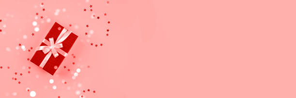 istock Banner made from red gift box on pink background with confetti. 1291146410