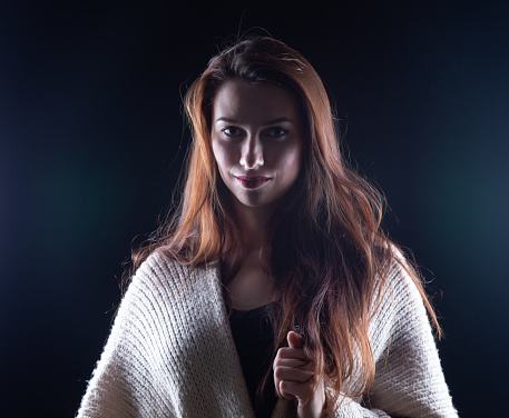 Photo of young woman with long hair on dark background