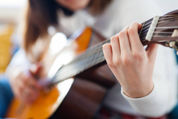 istock Holding strings down on acoustic guitar fretboard for a chord 1291150055
