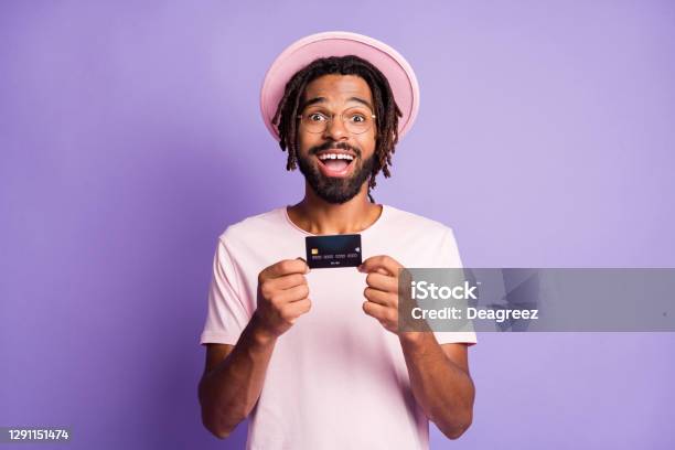 Photo Portrait Of Excited Guy Holding Credit Card In Two Hands Isolated On Vivid Violet Colored Background Stock Photo - Download Image Now