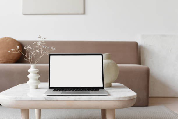 istock Laptop with blank empty white screen on table at home 1291151565