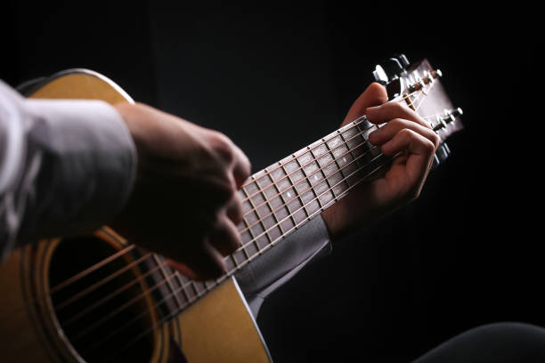 istock Young men playing the guitar with black background 1291151671