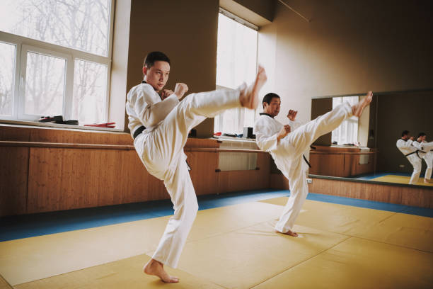 istock Two martial arts students in white keikogi doing karate stances. 1291154181