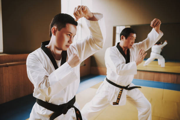 istock Two martial arts students in white keikogi doing karate stances. 1291154182