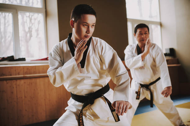 istock Two martial arts students in white keikogi training doing karate stances. 1291154183