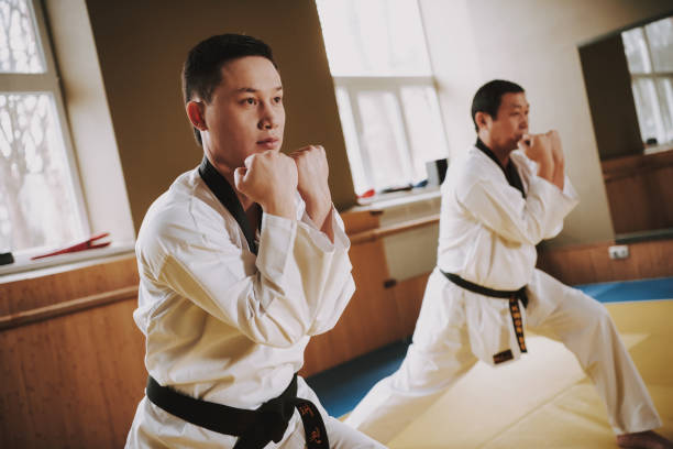 istock Two martial arts students in white keikogi doing karate stances. 1291154198