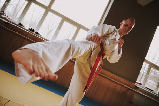 istock Bald martial arts fighter in white keikogi training moves. 1291154210