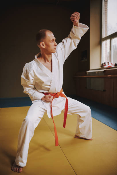 istock Bald martial arts fighter in white keikogi training moves. 1291154262