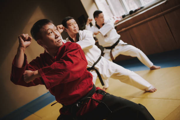 istock Sensei and two martial arts students doing fight moves together. 1291154311