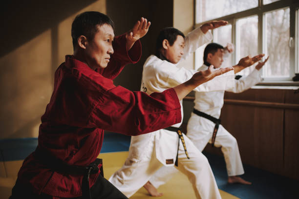 istock Sensei and two martial arts students doing stances together. 1291154340