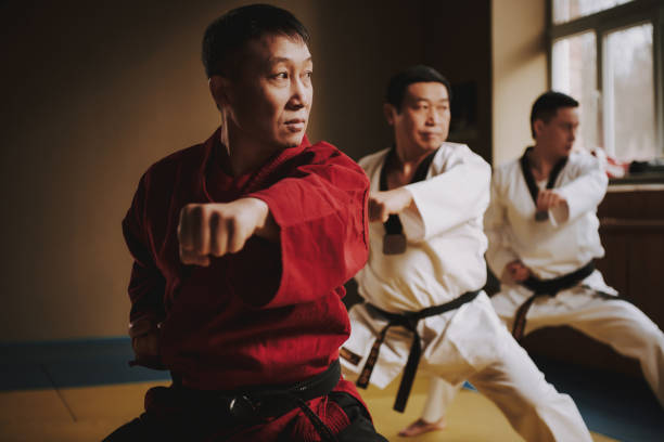 istock Sensei and two martial arts students doing stances together. 1291154384