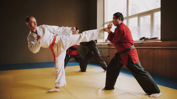 dois lutadores de artes marciais em keikogi branco e vermelho treinando juntos. - karate child judo belt - fotografias e filmes do acervo