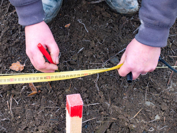 Surveying work. Worker marks the exact position on the soil for excavation work. stock photo