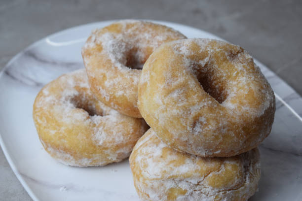 istock Delicious donuts with powdered sugar on plate 1291156906