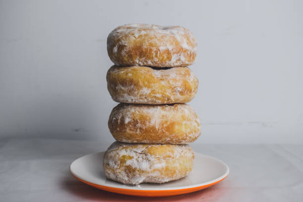 istock Delicious donuts with powdered sugar on plate 1291157014
