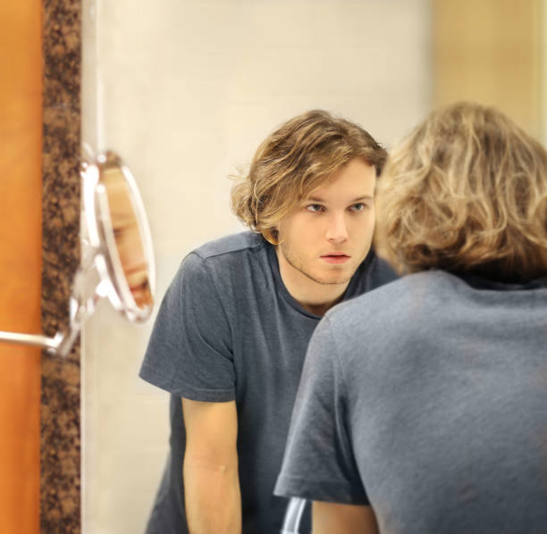 istock Applying the cream.young man looking in the mirror 1291157208