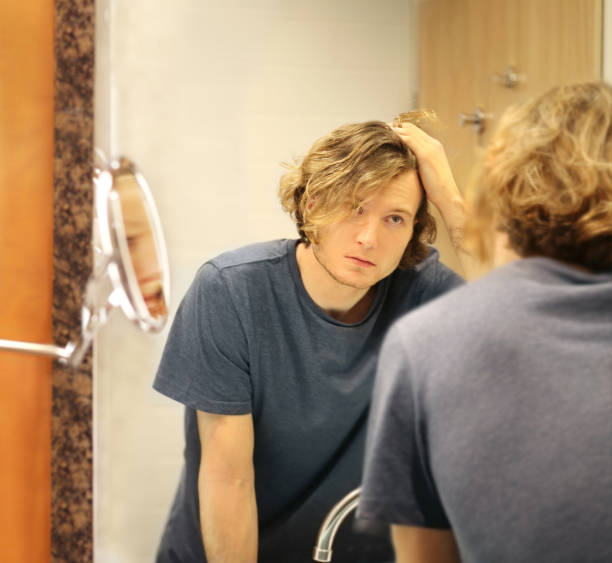 istock Applying the cream.young man looking in the mirror 1291157217