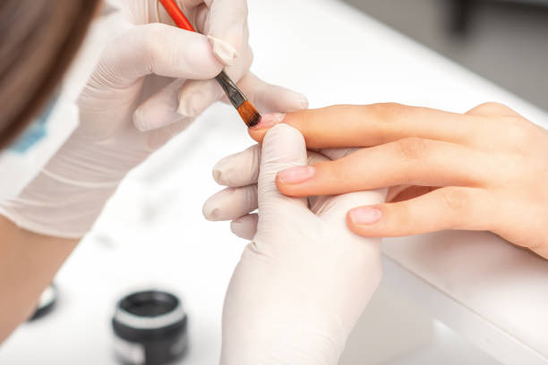 istock Manicurist covering nails with transparent polish 1291164578