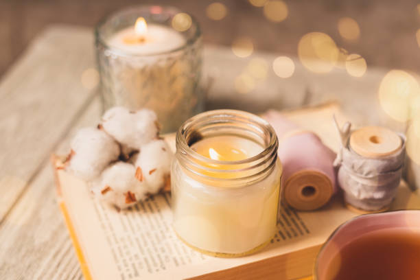 tasse de thé, coton, confortable, livre, bougie. concept d’hiver d’automne confortable. - bougie parfumer main photos et images de collection