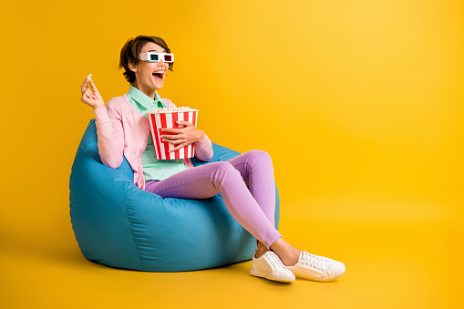 Full length body size photo woman 3d glasses watching television laughing isolated on vivid yellow color background looking at blank space.