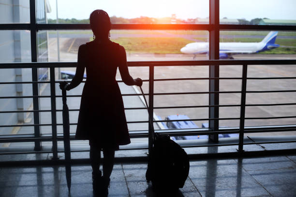 Silhouette of standing young Indian Businesswoman in Dabolim airport, Goa, India.