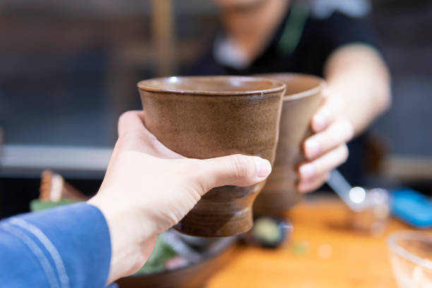 istock Two people toast with cups in a Japanese restaurant 1291170285