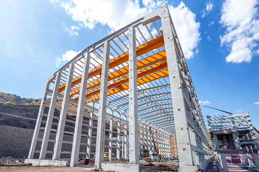 View of the prefabricated (precast) reinforced concrete industrial building. The entire building is erected with precast concrete elements, starting with the foundation, the columns, beams and walls.