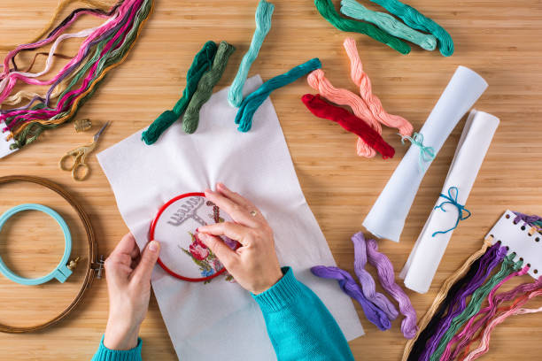 istock Female hands embroidering cross stitch on the canvas 1291172022