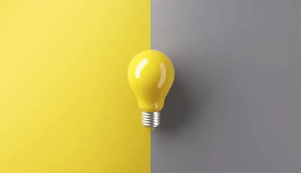 Photo of Ideas concepts, Creativity inspiration, White Lightbulb on grey and yellow background.