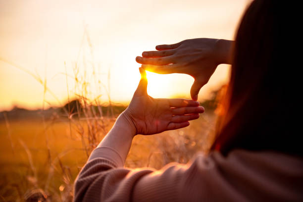 istock Future planning concept, Close up of woman hands making frame gesture with sunset. 1291173598