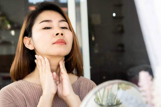 istock Asian woman doing self lymph node, checking thyroid gland on her neck 1291173625
