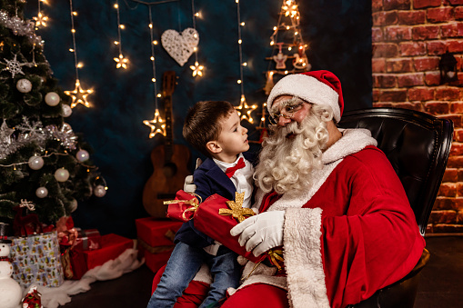 Santa has a real beard and the child looks at him with wonder, awe, and a hint of excitement.