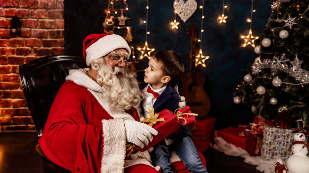Happy boy receiving a holiday present from Santa Claus in a cozy festive setting