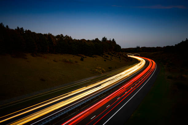 ampeln des verkehrs, der nachts auf einer autobahn vorbeifährt - traffic urban scene city nature stock-fotos und bilder