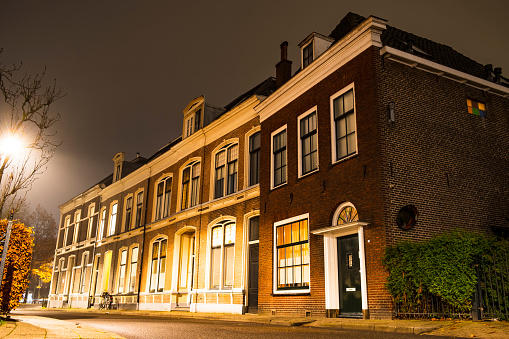 Row of old houses along a city street in the old town of Zwolle at night during a cold winter evening.
