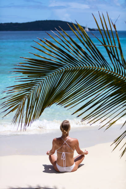 istock spiritual woman practicing meditation on a tropical beach 1291176722