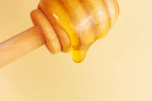 istock A drop of honey flows down from a wooden spoon 1291176798
