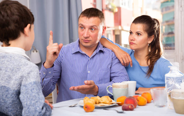 istock Father and mom scolding son in the kitchen 1291177102