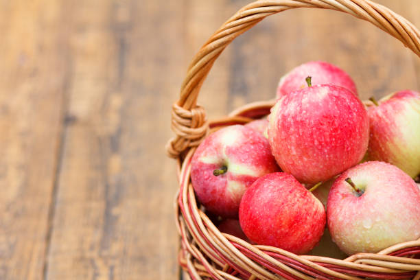 istock Red apples in wicker basket on wooden boards 1291177648