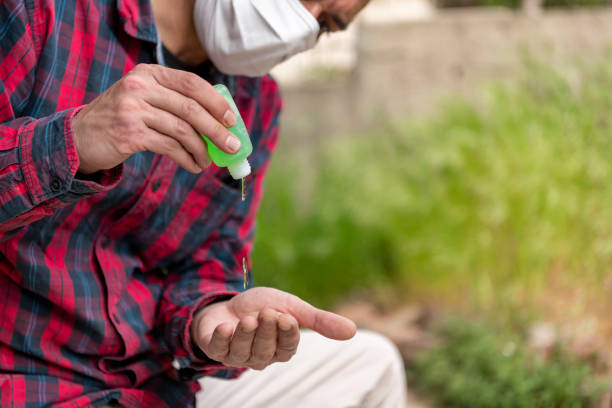 istock Businessman with a Protective Mask is Using Disinfection Gel to Wash his Hands to Avoid Coronavirus. 1291177784