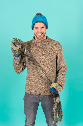 being in playful mood. men knitted cloth and accessory. male blue background. poor homeless man. cheerful man feeling cold in winter. no flu. winter weather forecast. guy wear warm clothes.
