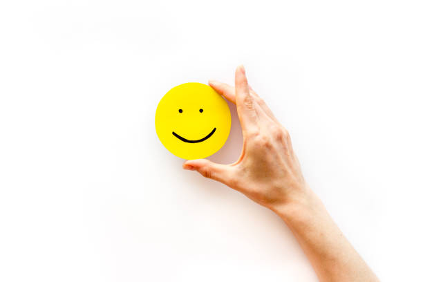 istock Smiling face emotion concept. Smile face on paper banner, top view 1291180052
