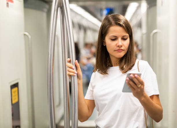 istock Woman using phone in subway car 1291180311