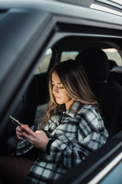 istock Young woman using a smart phone in a car 1291180640