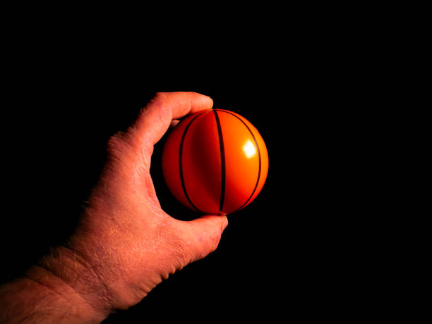 istock Basketball ball in hand on a black background. 1291180870
