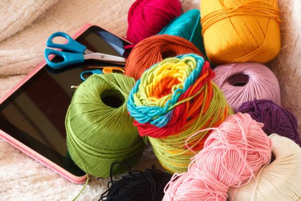 istock tablet with colored threads and wool and crochet needles for online classes 1291181984