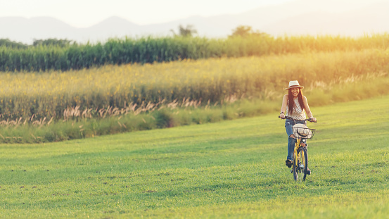 Lifestyle woman with bicycling at the garden meadow in sunset near mountain background.  Lifestyle  Concept