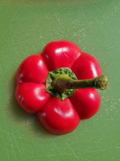 pimentão vermelho em um fundo verde - green bell pepper bell pepper red bell pepper groceries - fotografias e filmes do acervo